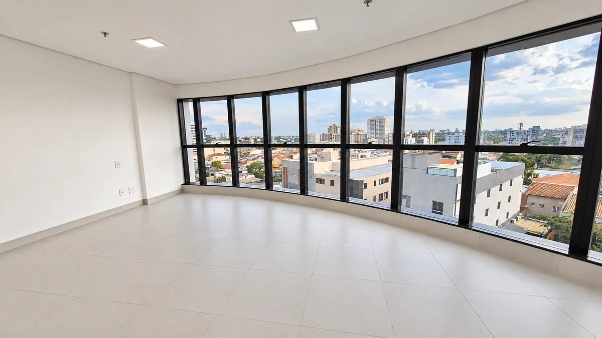 Sala comercial com fachada envidraçada e vista da cidade