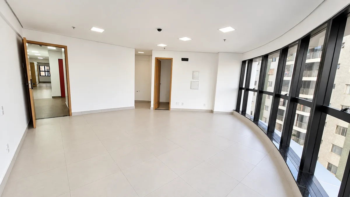 Sala comercial com fachada de vidro curva e porta de acesso